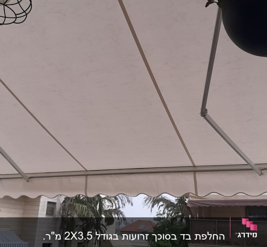 סוכך לבן מתוח מעל מרפסת עם שולחן וכיסאות
